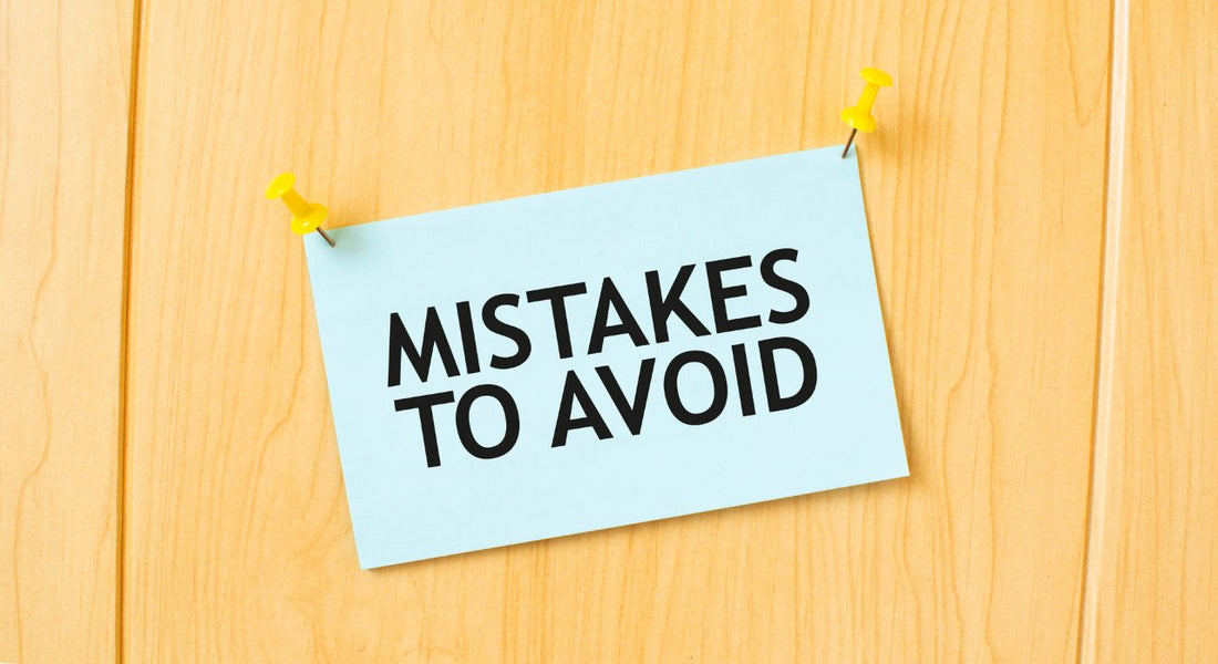 MISTAKES TO AVOID sign written on sticky note pinned on wooden wall
